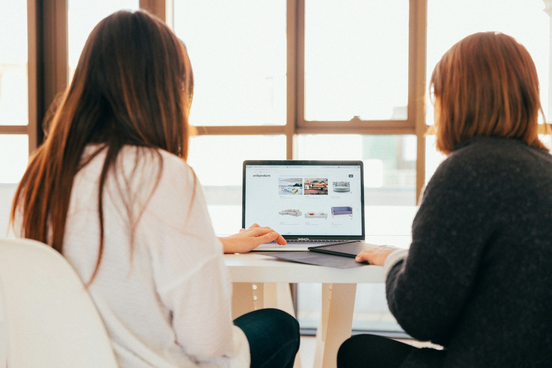 A consultant and a parent sitting at a table, looking at a chart with multiple paths, symbolising the different factors and personalised solutions they can explore. The setting is a modern, comfortable office.