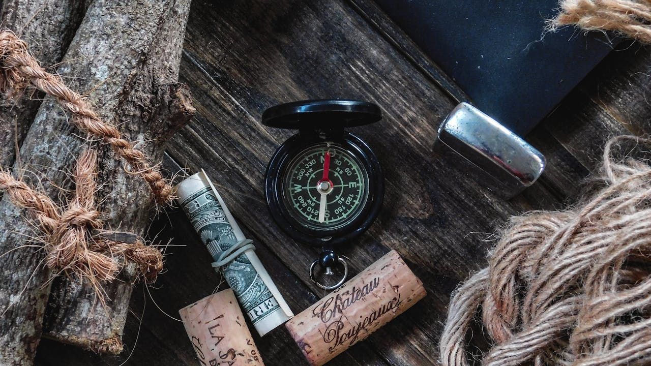 A person's hand holding a compass, with the needle pointing towards a star. The star is labeled "Financial Goals," symbolising the role of guidance in navigating the CPF Investment Scheme toward your objectives.
