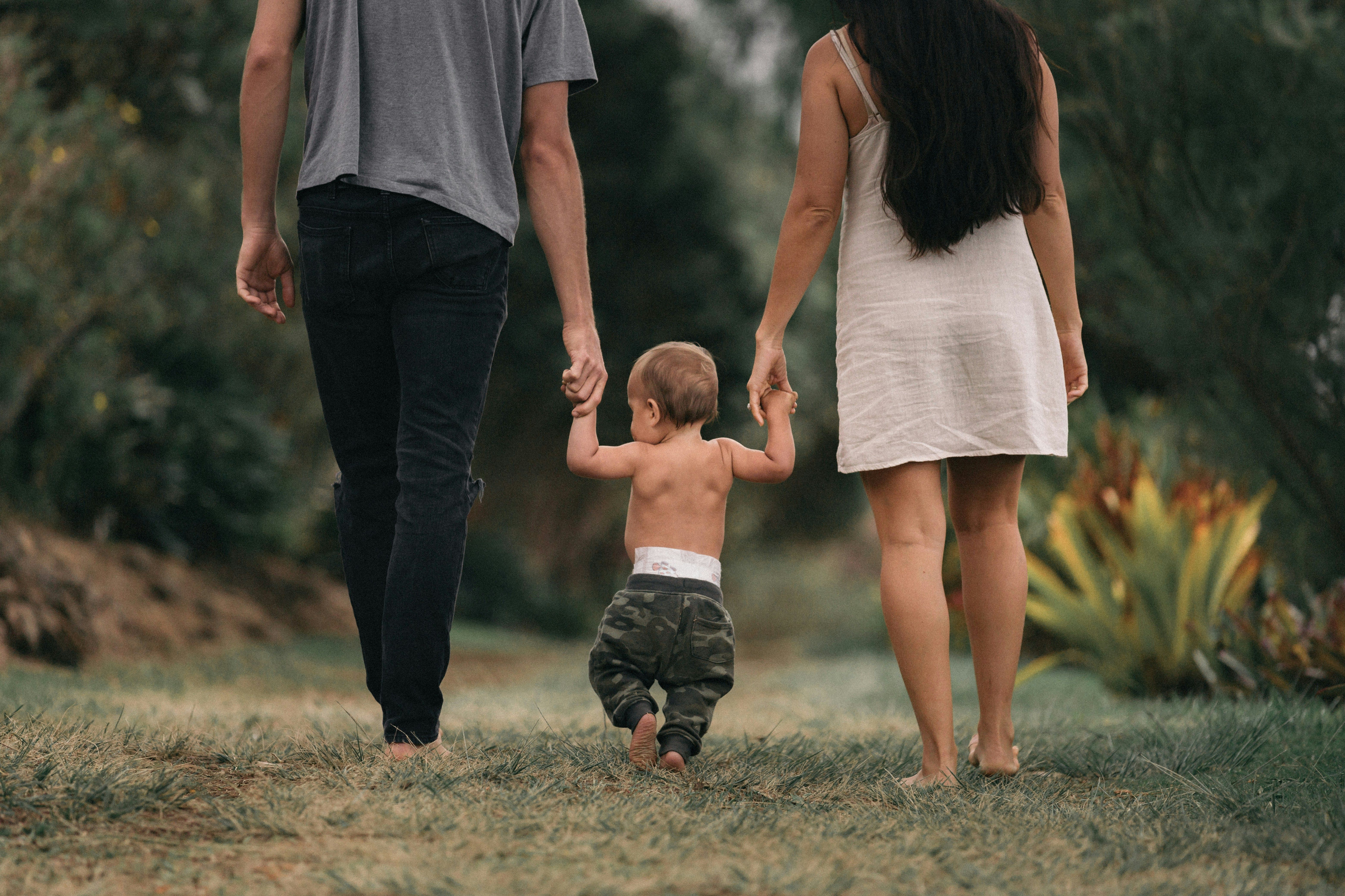 A silhouette of a family—a parent and two children—standing together on a hill, looking out at a peaceful, sun-filled landscape. A series of interconnected lines or a network is visible, starting from the parent and branching out to the children, symbolising a secure financial safety net.